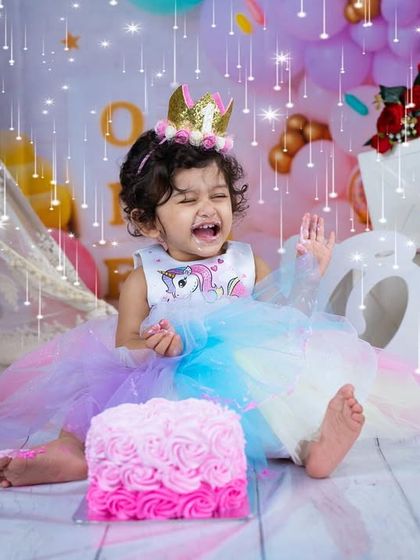 Sometimes the cake is just too exciting! This candid shot captures a moment of overwhelming joy and a little bit of birthday drama during a unicorn-themed cake smash.