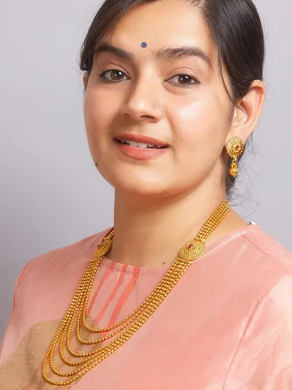 A model wearing our South Indian gold-plated Rani Haar necklace set. This multi-layered ball chain necklace gives a rich, traditional look.