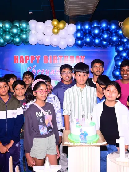 I also cover birthday parties for teenagers. This is a group photo from a 15th birthday celebration, capturing the birthday boy with his friends in front of a custom blue and gold balloon backdrop I set up for the event.