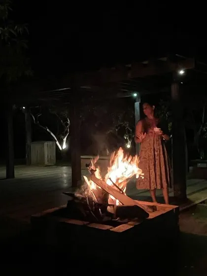 Standing by the warmth of a bonfire at night.