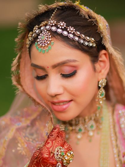 A close-up on the dreamy pink eye makeup and the intricate matha patti, a perfect combination for a morning bride.