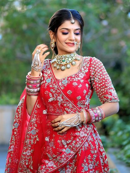 A complete bridal look featuring a heavy, gold-plated Kundan necklace, haath phool, and maang tikka, all available for rent.