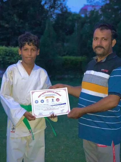A student receiving his certificate after a successful belt test from Sensei Amresh Singh, General Secretary of SKAF.