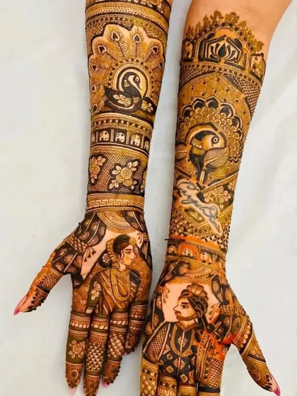 This design features portraits of the bride and groom on separate hands, with beautiful peacock and elephant motifs on the arms.