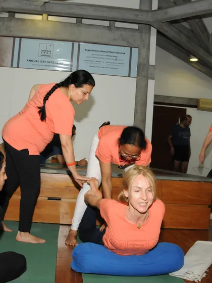 A guest teacher, Shobha Shetty, provides a hands on adjustment to a student during our Annual Day workshop. This shows our commitment to bringing diverse expertise to our students.