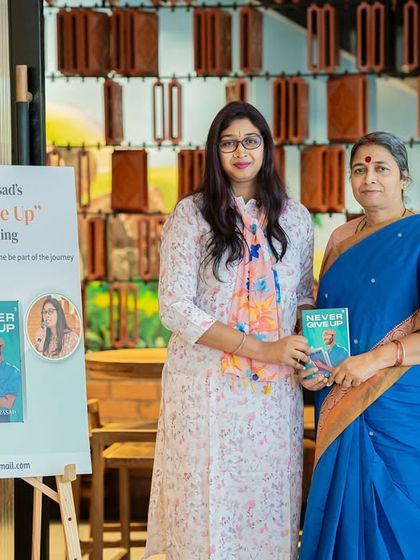 Author Divya G Prasad posing with a reader and her new book, a cherished photo opportunity we facilitate at our events.