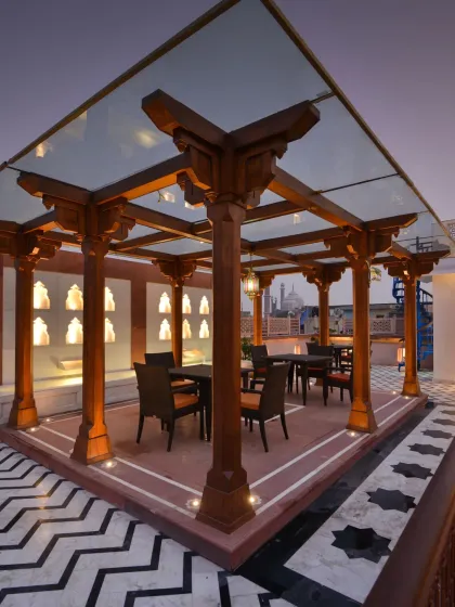 The rooftop terrace at Haveli Dharampura, designed to be an experience in itself. The 'Barah Dhari' structure offers a place for quiet reflection or dining, with magnificent views of Old Delhi's historic skyline, including Jama Masjid and the Red Fort.