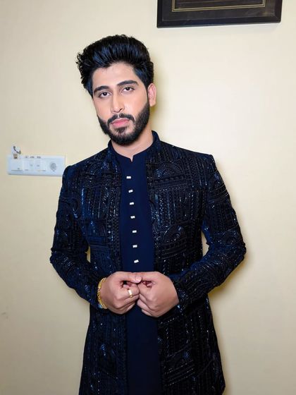 This groom's style is all about understated elegance. The clean lines of the outfit are matched by precise grooming and hairstyling.