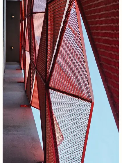 A view from the building's corridor, looking out through the geometric facade.