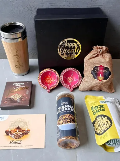 I also create custom hampers for festivals like Diwali. This set for Infosys combines a personalized bamboo travel mug with festive diyas, assorted snacks, and a branded greeting card, showing how we can mix practical items with seasonal treats.