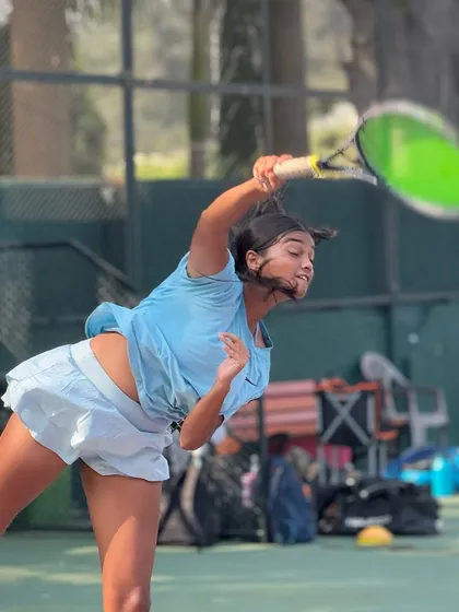 Capturing the power and grace of a well-practiced serve. One of our female junior players demonstrates excellent form and explosive movement during a practice session.