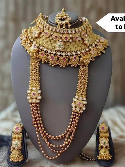 Introducing a masterpiece from my exclusive 'for sale' collection. This regal bridal set includes a broad choker, a layered rani haar with intricate floral motifs, and matching jhumkas, all crafted with polki and ruby-colored stones. This is an heirloom piece, designed to be treasured for generations.