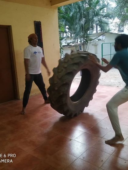 Two students work together on a tire flip drill. We push each other to get stronger.