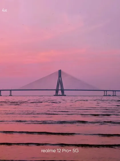 A 4x zoom mobile photograph of the Sea Link, bringing the structure closer while still retaining the beautiful pink hues of the water and sky.