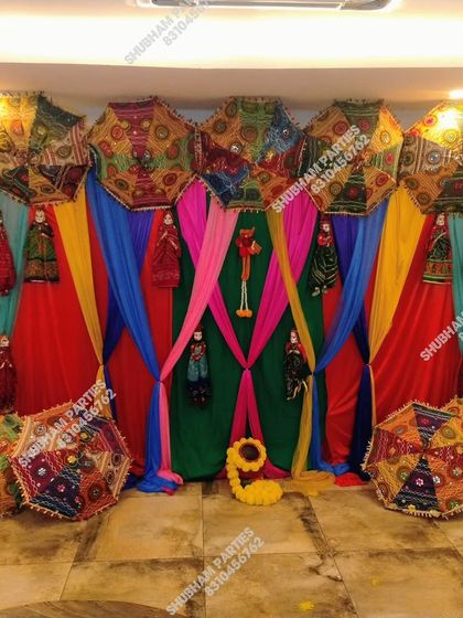 A colorful and vibrant backdrop with Rajasthani umbrellas and puppets, ideal for a Mehendi or Sangeet ceremony.