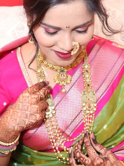 This client is admiring her complete look, featuring a long pearl haar and a choker, which are staples of Maharashtrian bridal jewellery.