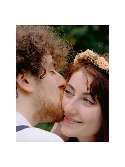 A gentle kiss on the cheek, a quiet smile. A tender and intimate portrait from their hand-fasting ceremony in a Swiss garden.