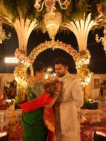A quiet moment of connection amidst the grandeur of the wedding ceremony. We focus on capturing these subtle interactions that speak volumes about the couple's bond, set against the backdrop of a magnificent floral mandap.