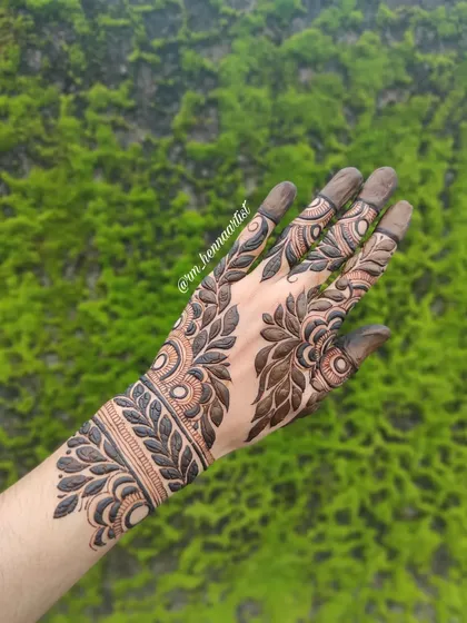 A beautiful bold henna design I did for myself, shot against a natural green background. The design really stands out.