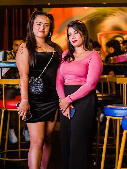 Two friends posing for a photo near the bar.
