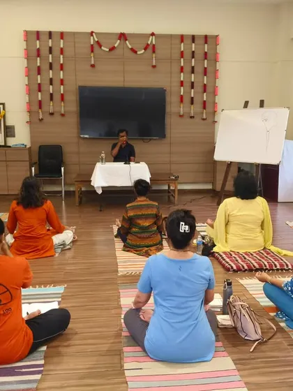 From the back, we see participants fully immersed in the Pranayama workshop. The setup is designed to facilitate learning, with a clear view of the instructor and a peaceful atmosphere.