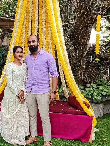 A lovely couple photo, with the client wearing her custom white Chikankari gown at an outdoor event.