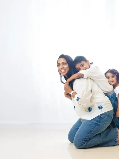 A playful moment between a mother and her children against a clean, white backdrop. This minimalist style puts all the focus on their joy and connection.