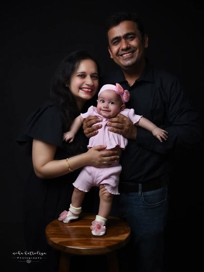Using a simple prop like a stool can add variety to poses in a family session. This pose allows the baby to be safely supported while being the center of attention.