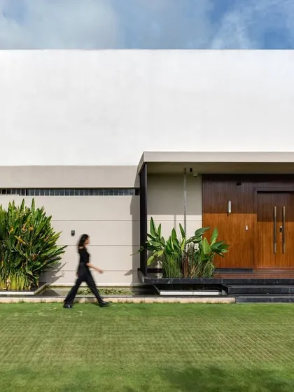 The architectural facade of the Celadon residence combines clean, monolithic forms with warm wood and lush tropical plantings. This composition demonstrates our approach to modern architecture that is both striking and harmoniously integrated with its natural surroundings.