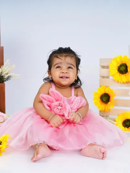 Her smile is as bright as the sunflowers around her. I guide the children to interact with the props for natural and engaging photos.