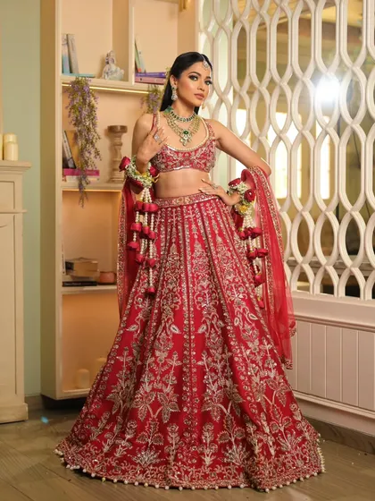 This vibrant red lehenga deserved a powerful pose. The dupatta is styled to showcase the detailed blouse and skirt, creating a look of pure confidence for this beautiful bride.