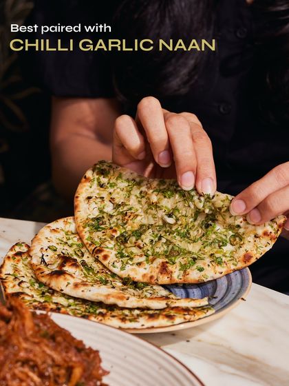Our crowd-favourite Chilli Garlic Naan, generously topped with fresh garlic and herbs. It's the perfect partner for our slow-cooked Raan Musallam.