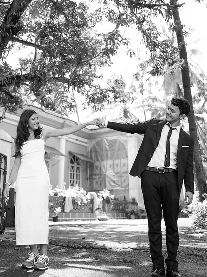 A fun and quirky black and white shot of the couple reaching for each other. This playful pose shows their unique personalities and the fun they have together.