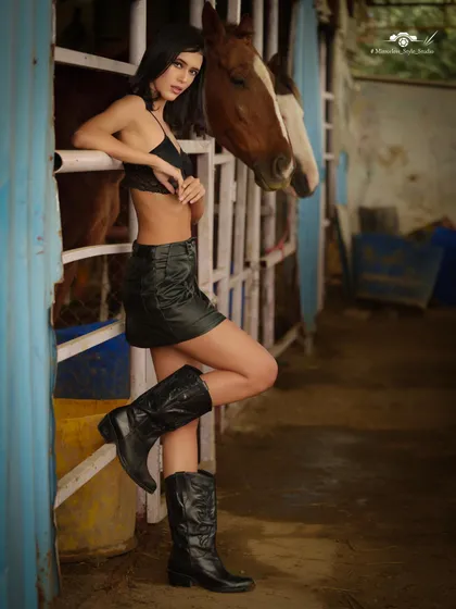 A full-length fashion shot in the stables, showing how the rustic setting complements a modern, edgy look.