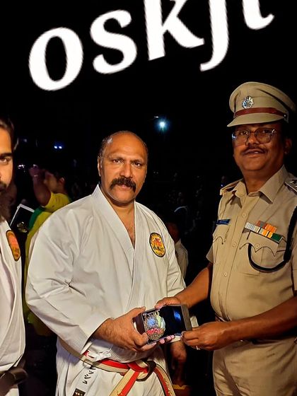 Receiving a token of appreciation from a police official after a karate demonstration. We are proud to collaborate with law enforcement agencies.