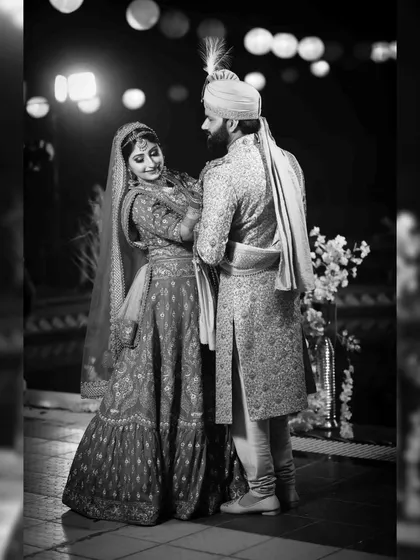 A classic black and white portrait of the couple on their wedding day. The beautiful bokeh from the lights in the background adds a touch of magic to this timeless shot.