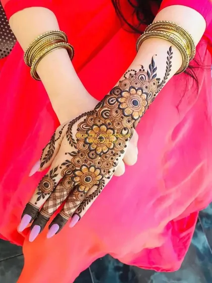 This floral vine design is a popular choice for its elegance. It gracefully adorns the hand and is perfect for bridesmaids or party guests.