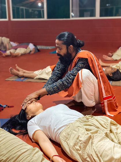 I offer a Shavasana adjustment, gently pressing on the forehead to help a student release mental tension and surrender completely. The final resting pose is one of the most important parts of the practice.