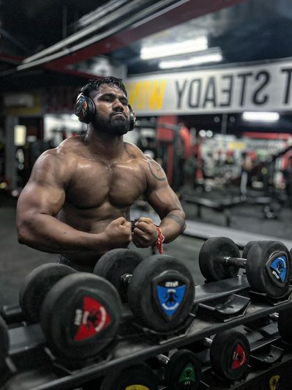 No need for validation. A powerful pose in front of the dumbbell rack.