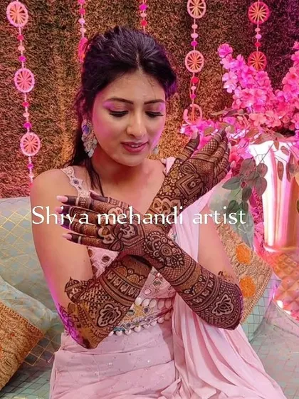 A bride displaying her elegant floral and paisley mehendi on the back of her hands, perfect for her special day.