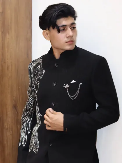 A closer look at the lion-embroidered Jodhpuri jacket. The detailed threadwork on the sleeve and the crown brooch add a touch of royalty to this powerful design.