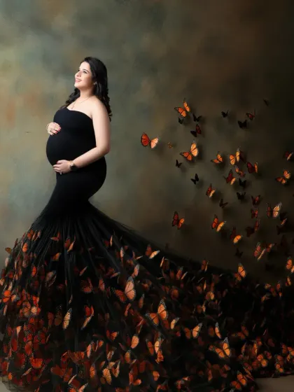A magical transformation. This conceptual portrait shows a mother-to-be in a black gown that dissolves into a flight of monarch butterflies, symbolizing change and new life.