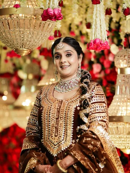 Against a backdrop of chandeliers and roses, this client's regal look truly shines. The makeup is sophisticated, with beautifully defined eyes and a flawless base that looks stunning under the event lighting.