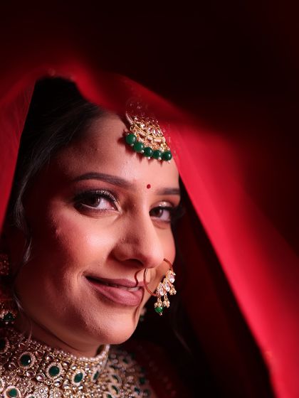 Urvashi's subtle and natural bridal look. We focused on soft, shimmery eyes and flawless skin to complement her gorgeous red lehenga and emerald jewellery.