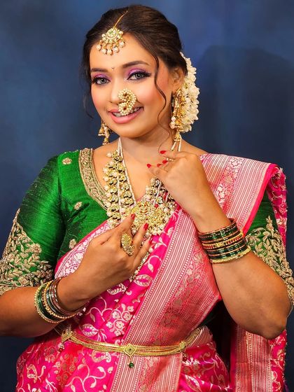 A full-length view of the bride, showing how the saree draping, makeup, and hairstyle all come together to create a cohesive and stunning look.