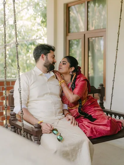 A quiet, candid moment of connection on a traditional wooden swing. The gentle affection and shared smile between the couple reflect the simple, profound joy that I strive to capture in my South Indian wedding photography.