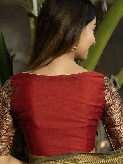 A back view of the maroon blouse with gold brocade sleeves. The boat neck cut is classic and elegant, showcasing the beautiful contrast between the plain body and patterned sleeves.