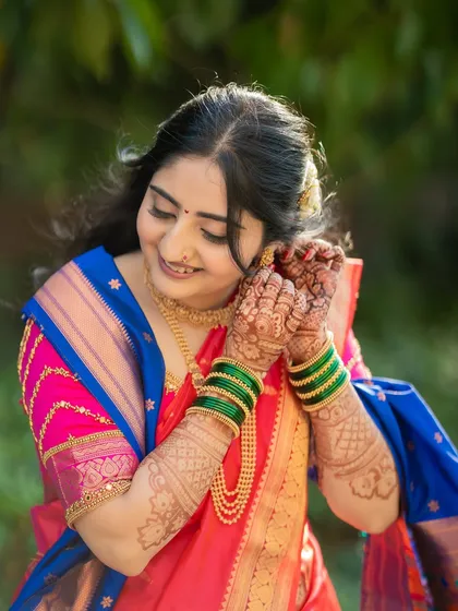 A beautiful candid portrait of the bride, Jagruti, adjusting her earring. These getting-ready moments are full of grace and anticipation.