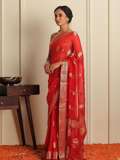 A full-length shot of a classic red saree for Binal Patel's "Rubaroo" festive edition. The set was styled with traditional elements like marigold flowers to create an authentic, celebratory atmosphere.
