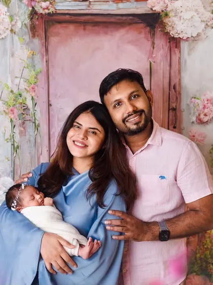 A smiling family portrait with their newborn. Our goal is to make you feel comfortable and happy, so we can capture your genuine joy.